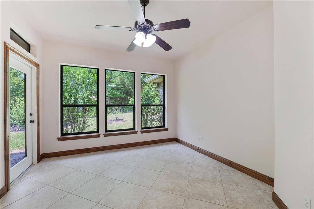 The sunroom/sitting room is located just off the primary suite and features beautiful views and tons of natural light!