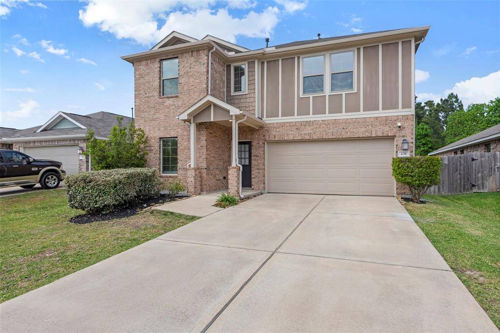 Welcome home to 438 Camas Creek Ln Magnolia, TX 77354 This photo shows a two-story brick home with a double garage. The front yard features a well-maintained lawn and shrubbery, and the driveway offers ample parking space. The exterior is classic and inviting, with a covered entryway.