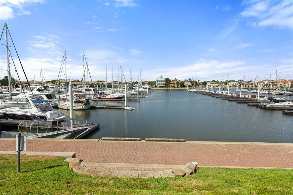 Scenic marina view with multiple boats docked, calm waters, and clear blue skies, perfect for boating enthusiasts or serene waterfront living.