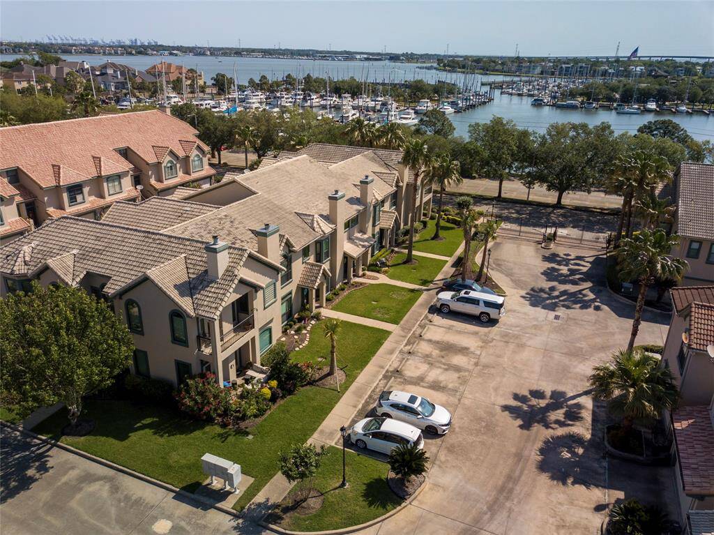 This photo showcases a row of modern luxury townhouses with a marina view. The properties feature well-maintained landscaping and are situated near the waterfront, offering a picturesque and serene environment.  Subject property outlined in red.