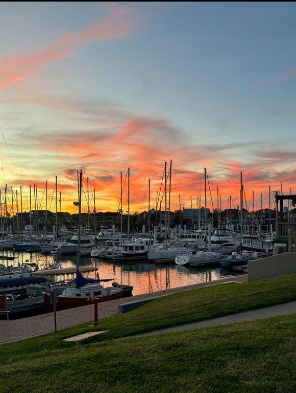 Stunning harbor view with boats docked at sunset, featuring vibrant skies and calm waters, perfect for a serene waterfront lifestyle.