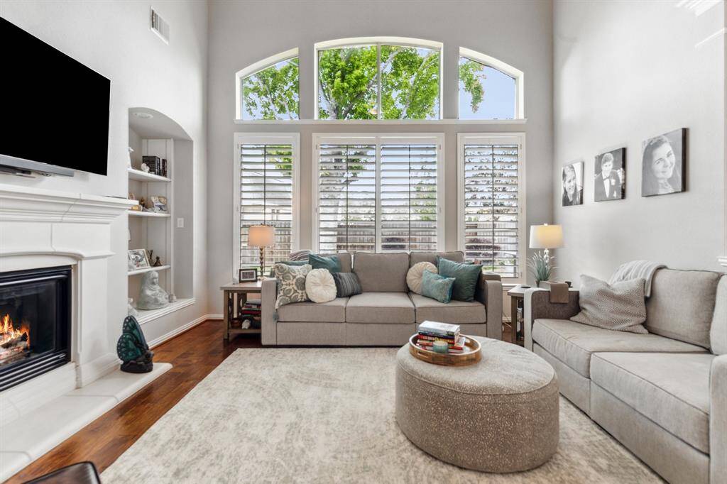 Attractive living space has cast-stone, gas-log fireplace, built-ins, quadruple windows with arched transoms overlook the large backyard. Two-story ceilings make for an elegant area to relax and entertain.