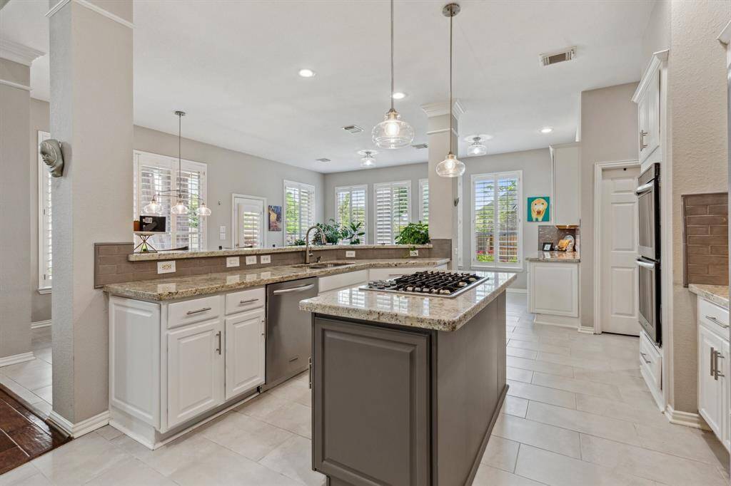 Plantation shutters enhance the windows of the breakfast space and the sunroom. This spacious area is terrific for gatherings and entertaining.