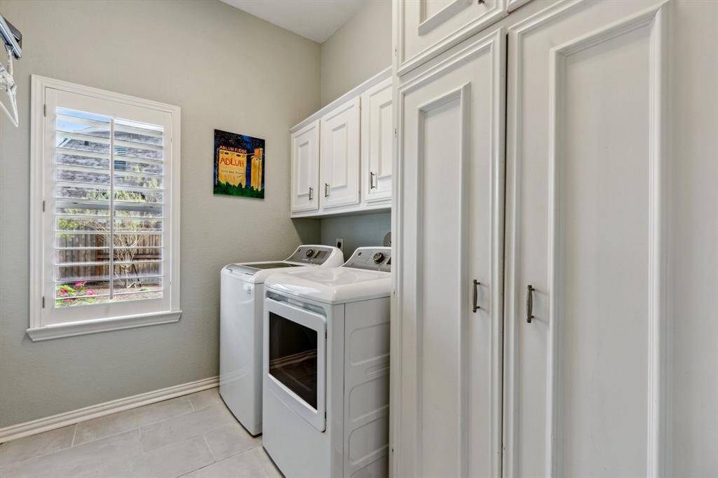 Spacious laundry room with upper cabinetry, plantation shuttered window for natural light and floor to ceiling storage closets with uppers. This laundry room is wired for both a gas and electric dryer.