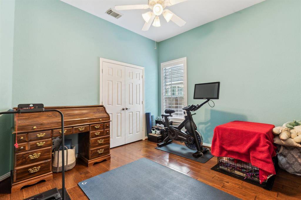 Downstairs guest room (now being used as a fitness room) has handsome wood flooring, double door closet and a ceiling fan. This is a great room for family and friends that cannot utilize the stairs. There is a bath in an alcove that services this room.