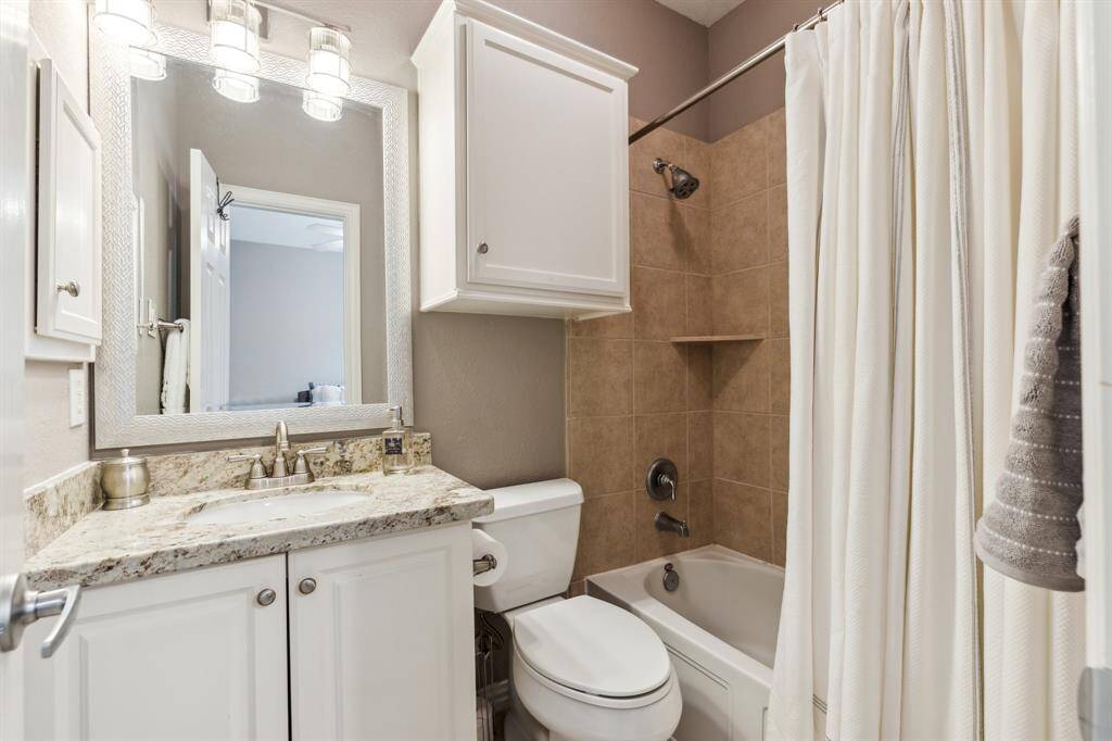 This is the ensuite bath for the room just shown. Granite counters, white cabinetry and combination tub/shower.