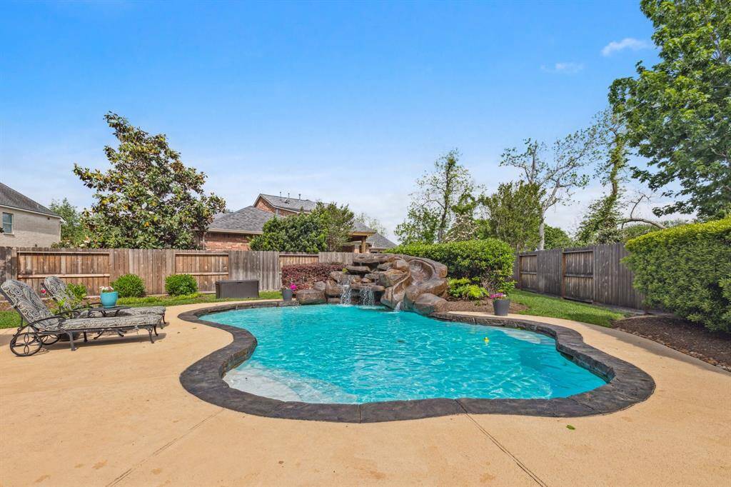Sparkling pool as so many updates . . . even a new state-of-the-art in-floor pool cleaning system, water feature with slide and grotto-style seat under the waterfall.