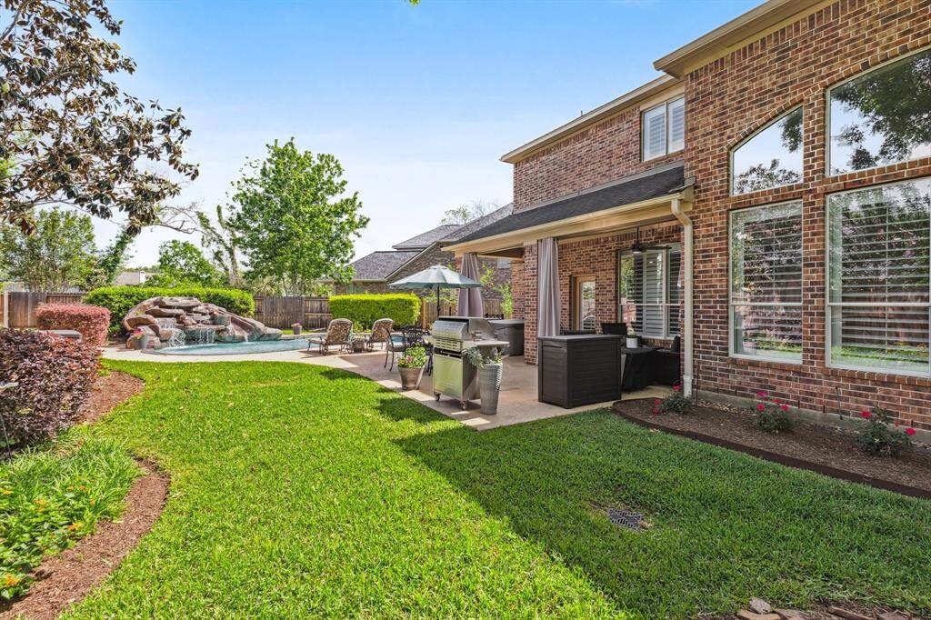 View of the back green space. Lovely landscaping is easy to maintain and the yard has French drains for water maintenance.