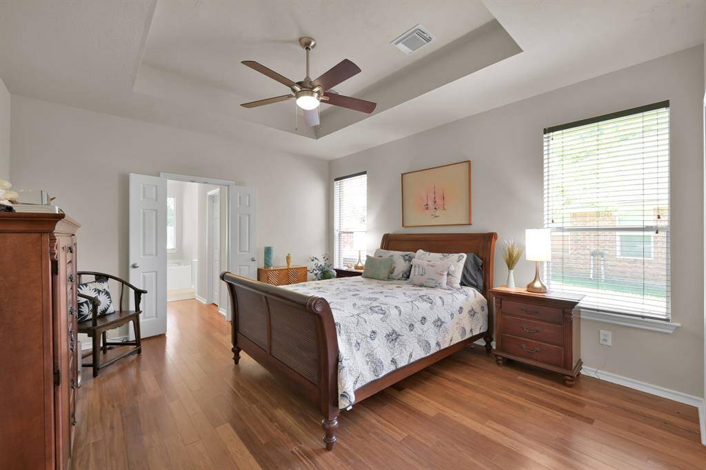 The serene owners suite offers a tray ceiling and warm bamboo flooring.