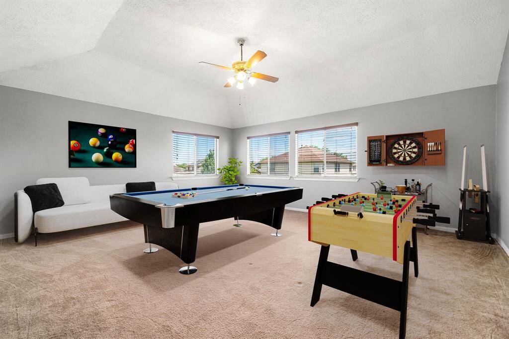 Perfect for entertaining is this amazing game room! Right upstairs this space would be a fabulous teen hangout, media room, or adult game room complete with pool table and big screen TVs. Featuring plush carpet, high ceilings, dark stained ceiling fan, custom paint and large windows with privacy blinds. *Virtually Staged