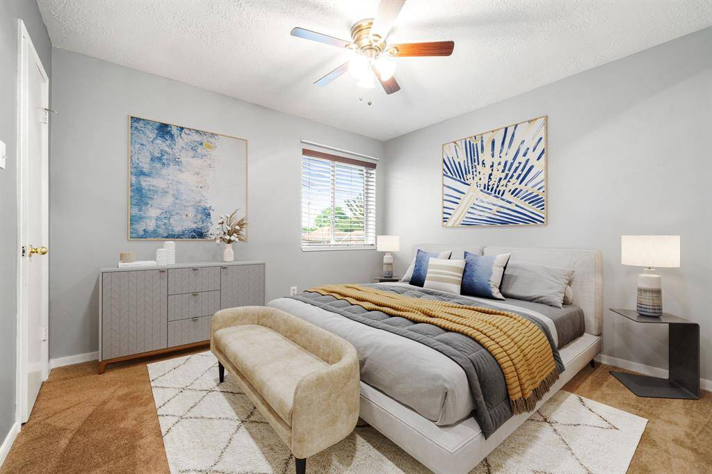 Secondary bedroom great for use as an in-law suite or guest suite features high ceilings, lovely modern ceiling fan, custom paint, plush carpet, space for seating area, direct access to the secondary bathroom and large window with privacy blinds. *Virtually Staged