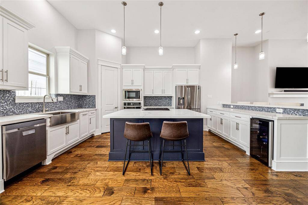 The chef-inspired kitchen boasts a spacious island with a built-in cooktop, making meal prep both functional and stylish. Abundant counter space, high-end finishes, and modern appliances create an ideal environment for cooking and entertaining.