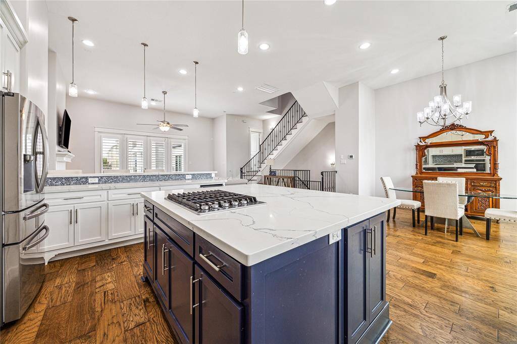 The kitchen, the true heart of this home, is open and inviting with soaring high ceilings that enhance the space’s sense of airiness.