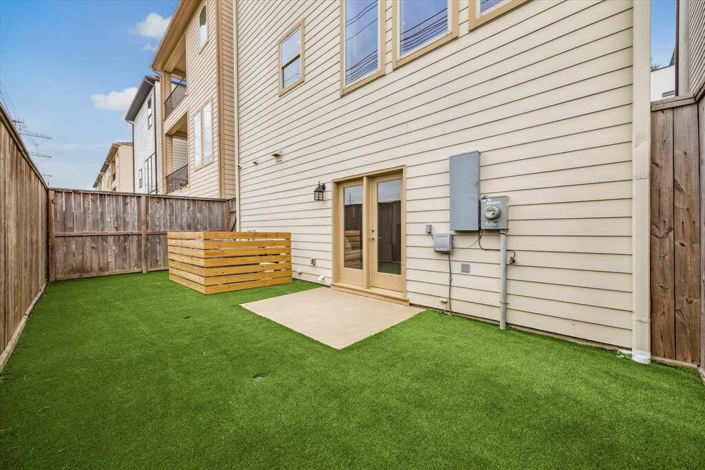 Low-maintenance turfed backyard with a clean, modern look—complete with fenced-in AC units for added safety and a polished finish.