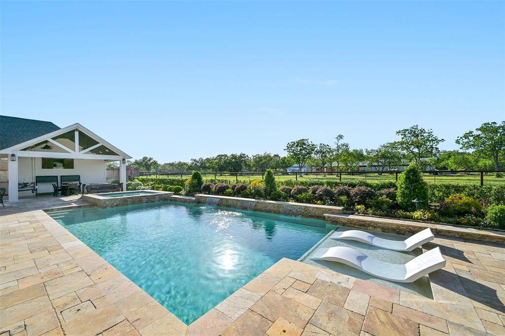 This photo showcases a luxurious outdoor space with a sparkling pool.