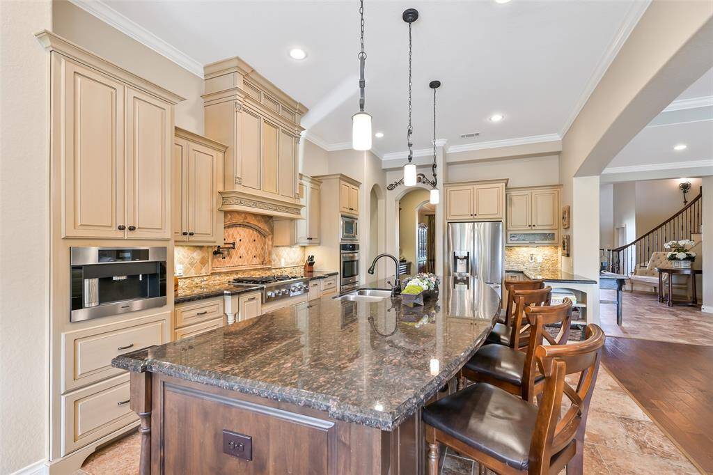 This spacious kitchen features a pot filler, Scotsman nugget ice machine, built in Miele espresso machine and warming drawer. The open layout leads to a cozy living area, creating a welcoming space for entertaining.