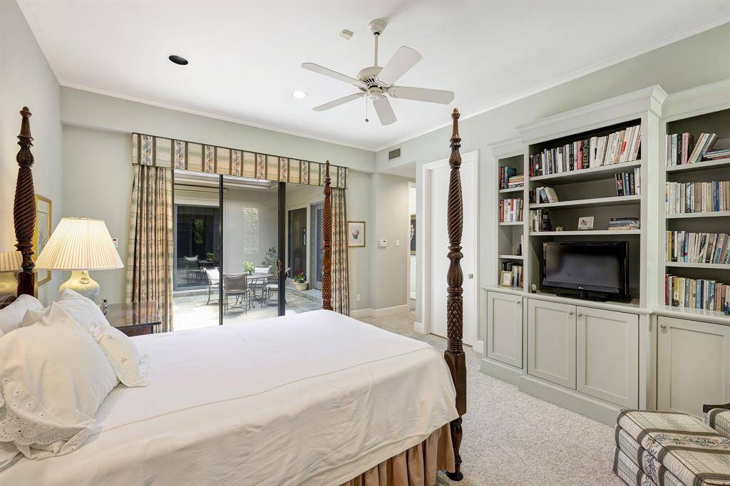 Another view of the primary bedroom showing the built-ins and view to the pool patio.