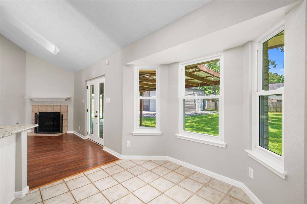 Breakfastroom features a bay window with views of a lush backyard. French doors enhance natural light and provide easy outdoor access.