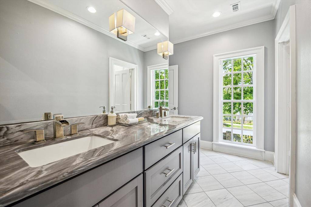 Bright and airy, this generously sized secondary bedroom offers classic details like crown molding, hardwood floors, and access to a private balcony.