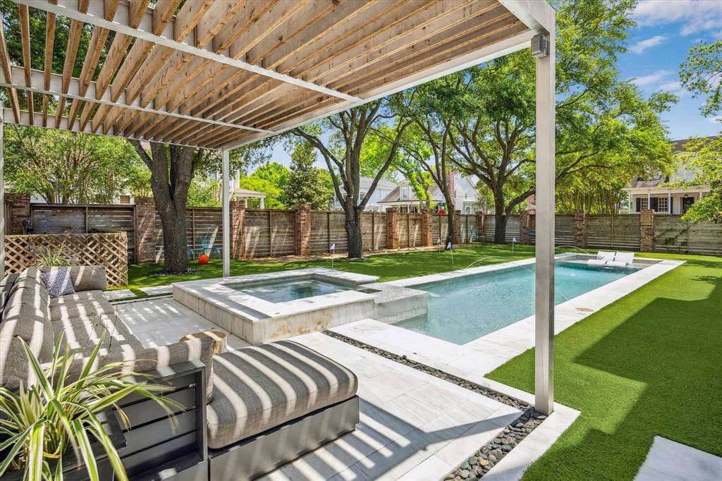 The expansive backyard is truly a private paradise with a resort-style pool, spa, putting green, and pergola-shaded lounge.