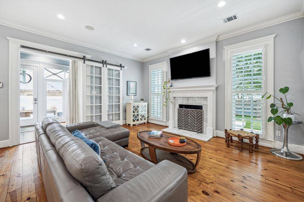 Comfort meets character in the family room, where a marble-surround fireplace is flanked by tall windows with plantation shutters.