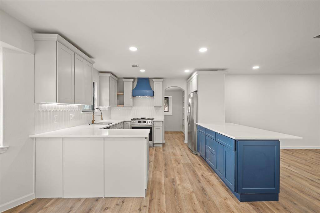 Kitchen features sleek stainless steel appliances, quartz countertops, and a custom backsplash, it offers both style and durability.