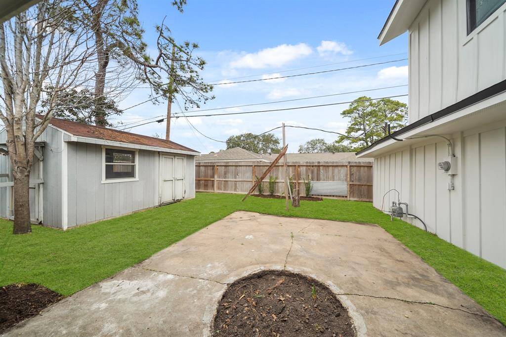 A convenient storage shed sits in the corner, providing extra room for tools and equipment.