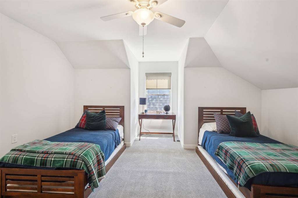 This cozy third floor bedroom features a central window with natural light, and a ceiling fan, creating a bright and inviting space.