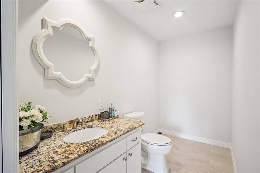 This third floor bathroom shows a has granite countertop, white cabinetry, and a stylish mirror. It has space and plumbing for an additional shower.