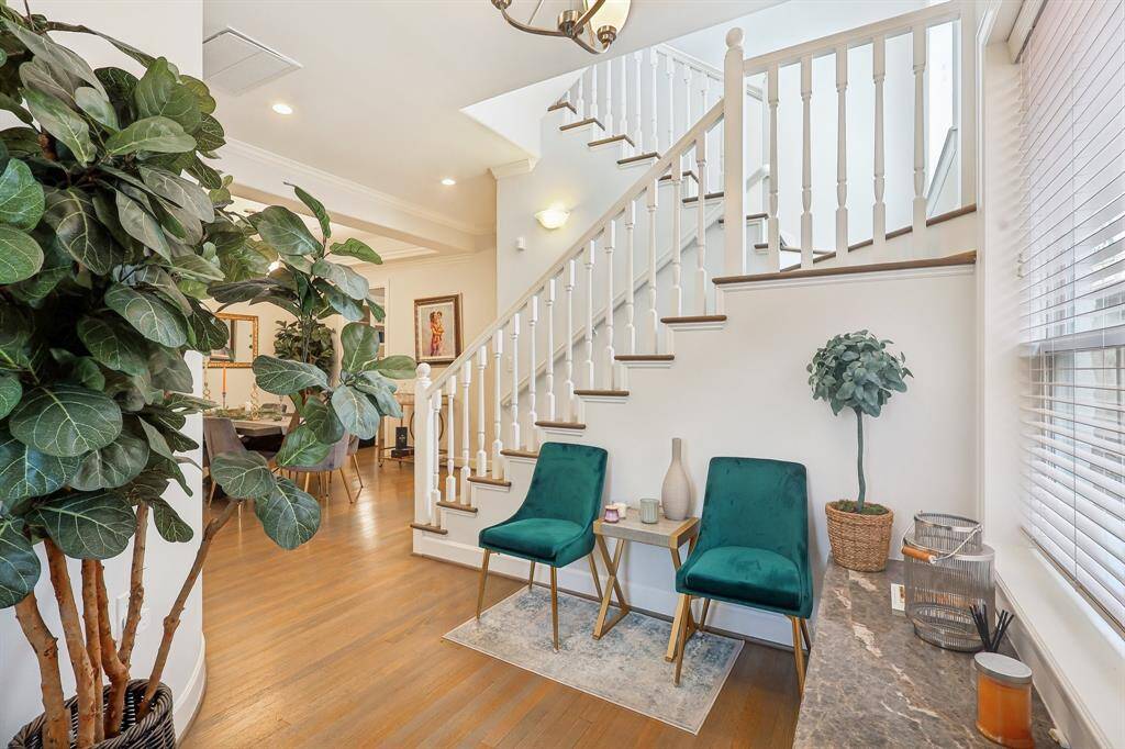 This inviting entry features a bright, open space with a staircase leading upstairs. The area is well-lit with natural light from a large window, creating a warm and welcoming atmosphere.