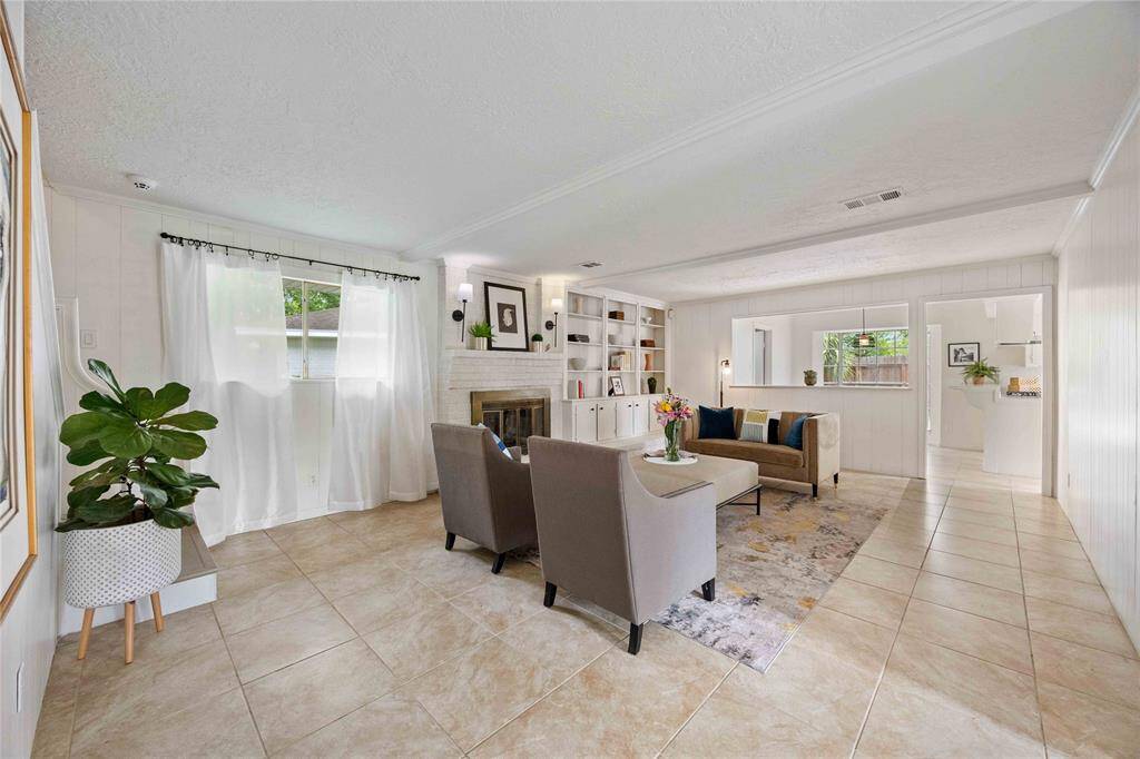 Spacious family room with wood burning fireplace and custom built ins