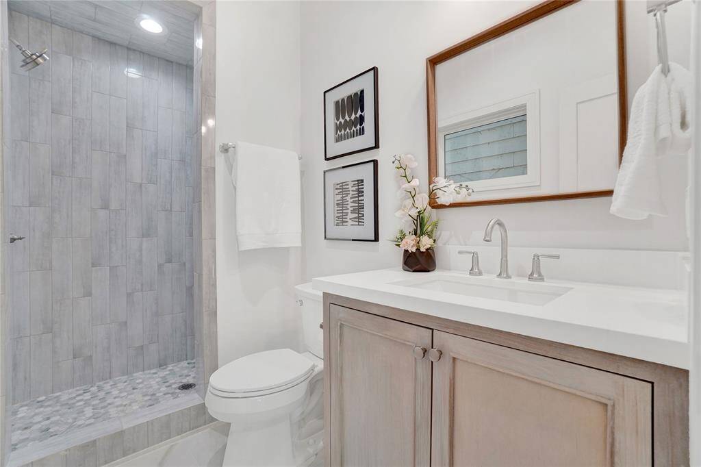 *Photos are from 5435 Darling* First floor full bathroom with custom made cabinets and a fully tiled standing shower.