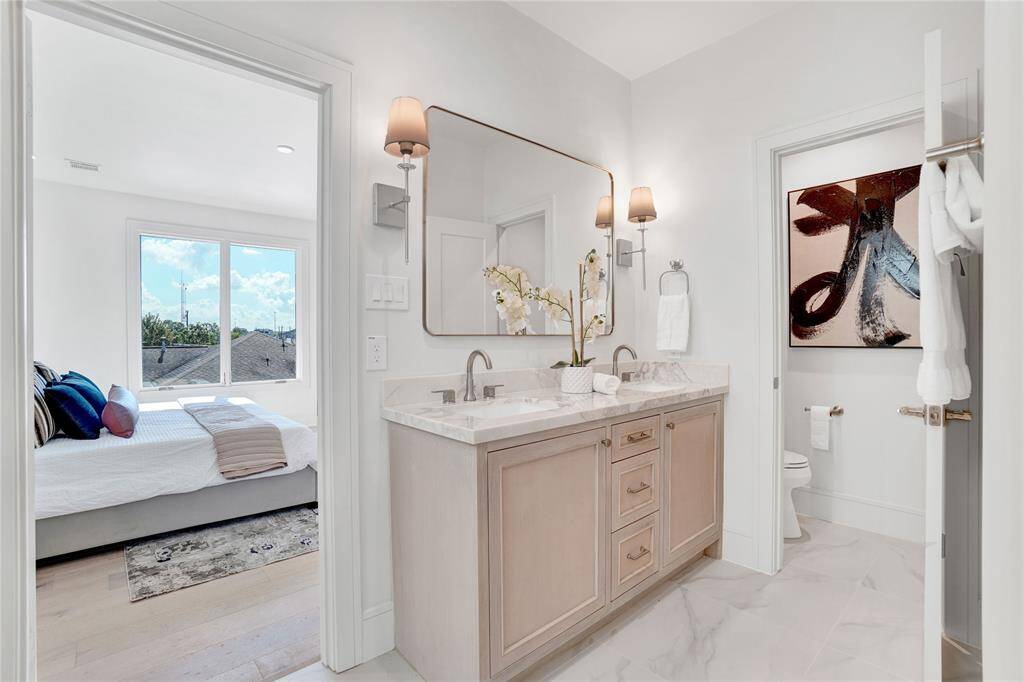 *Photos are from 5435 Darling* Primary bath with natural stone double-sink vanity, soaking tub with an amazing view, and a standing shower with custom tiles from floor to ceiling.