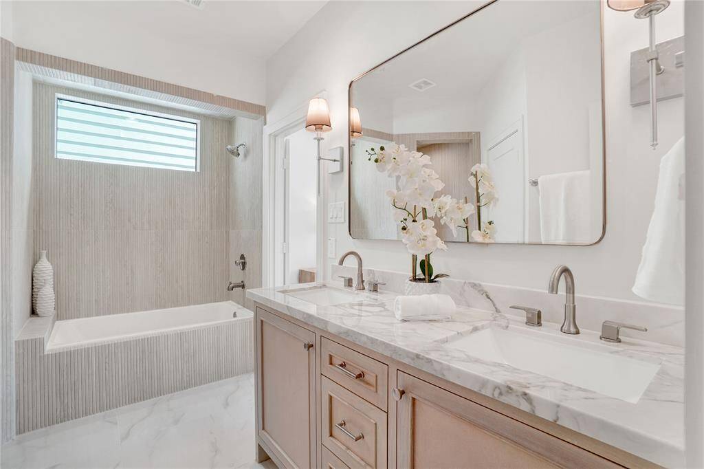 *Photos are from 5435 Darling* Primary bath with natural stone double-sink vanity, soaking tub with an amazing view, and a standing shower with custom tiles from floor to ceiling.