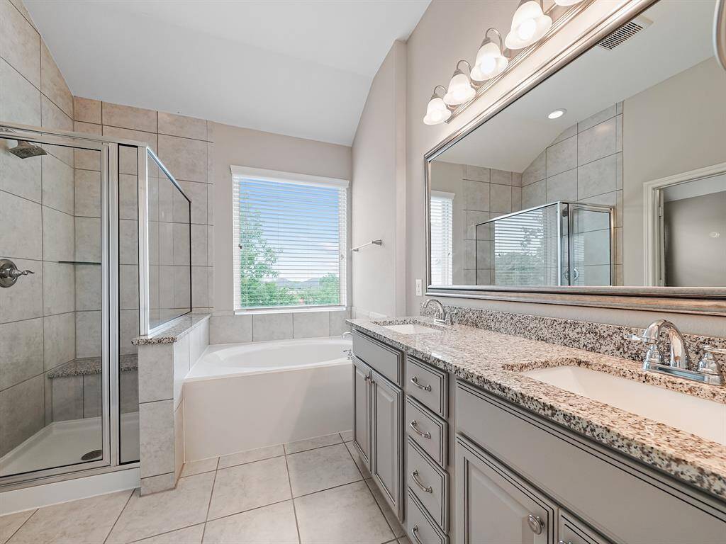 Enjoy the convenience of a separate shower with bench seating and the relaxation of a soaking tub. This meticulously designed space offers both functionality and tranquility.