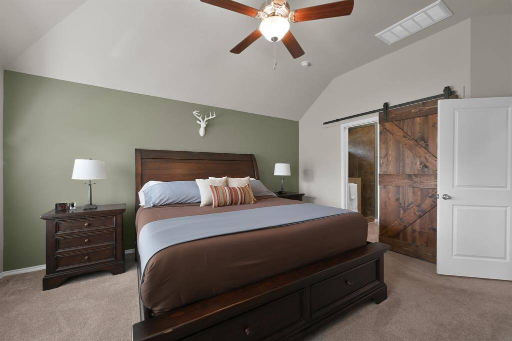 Primary bedroom features an upgraded barn door leading into the primary bathroom.