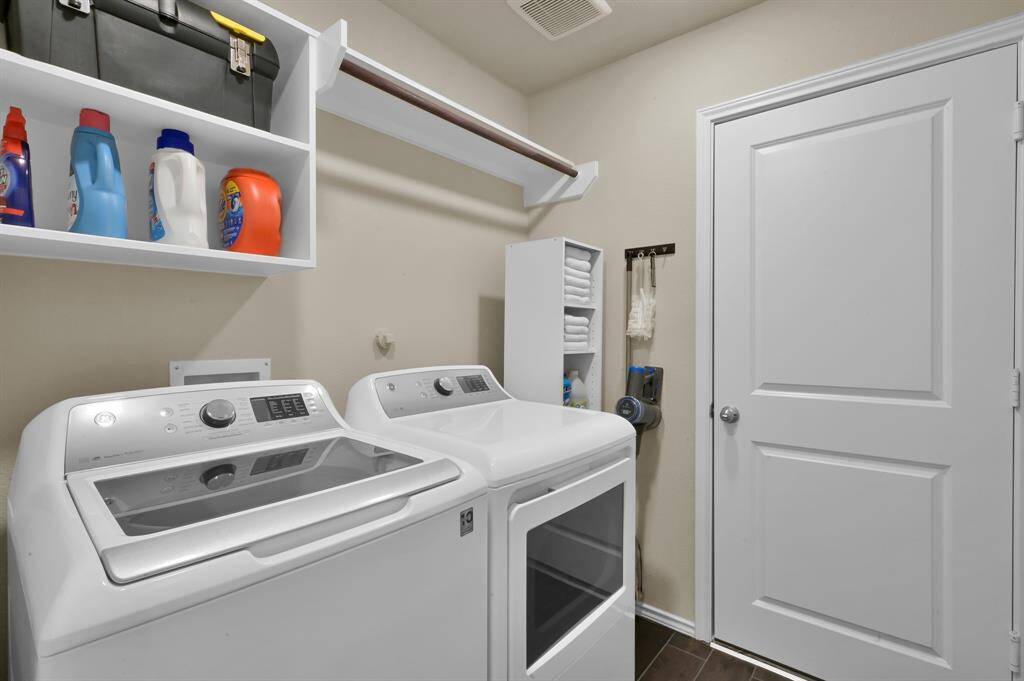 Utility room located in the home with a pass through to the garage that features epoxy floors and an insulated garage door!