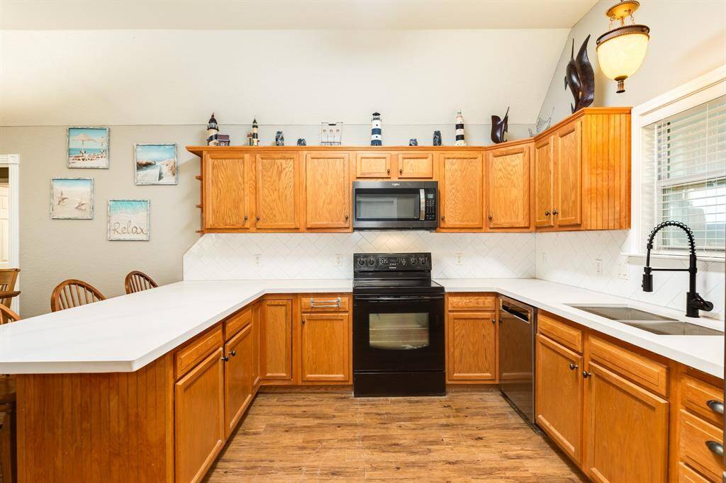 Bright kitchen featuring wooden cabinetry,  and recently installed quartz white with gray countertop. The room is accented with decorative items and wall art, creating a welcoming atmosphere.