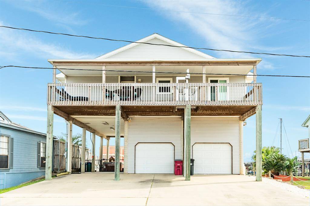 This elevated coastal home features a spacious covered deck, two-car garage, and ample driveway. Ideal for enjoying outdoor views.
