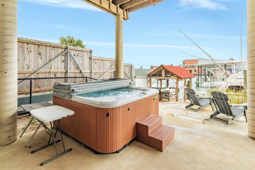 This outdoor space features a private hot tub, patio seating, and a view of the marina, perfect for relaxation and entertaining.