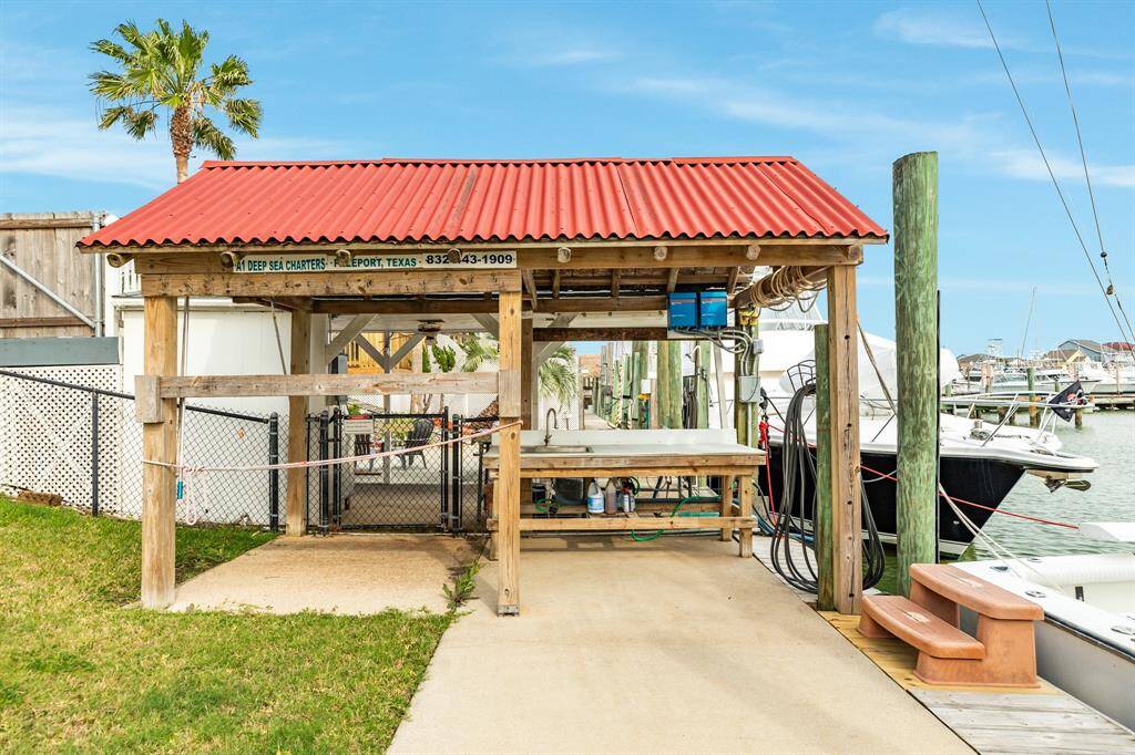 This photo shows a canal front dock area with a covered fish-cleaning station topped by a red roof. It's adjacent to a marina with boats, offering convenient access for boating and fishing enthusiasts.