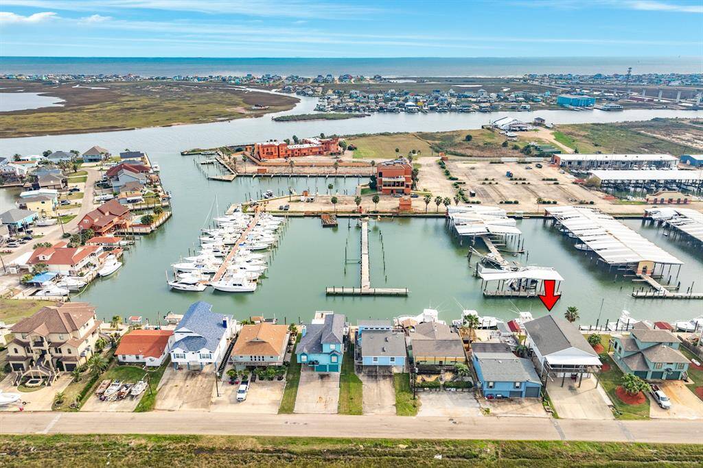This aerial photo showcases a waterfront property with direct access to a marina under renovation, surrounded by similar homes. The property offers scenic views of the water and is located in a vibrant coastal community.