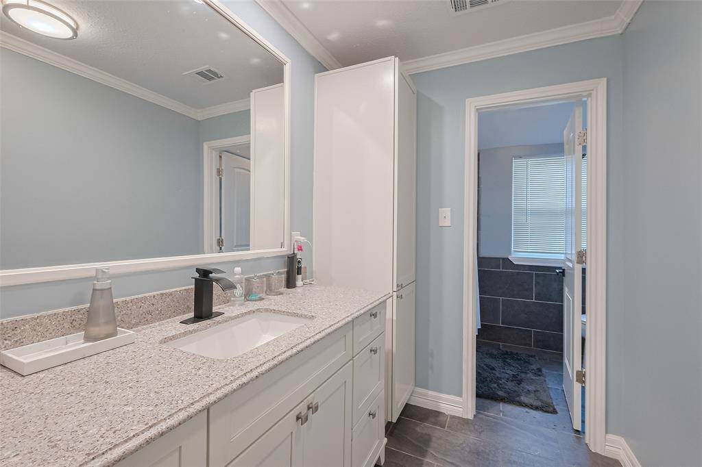 Updated secondary bath includes undermount sink, and sleek faucet. It has ample storage with a tall cabinet and full sized mirror! The private shower/tub/toilet combo & tile flooring