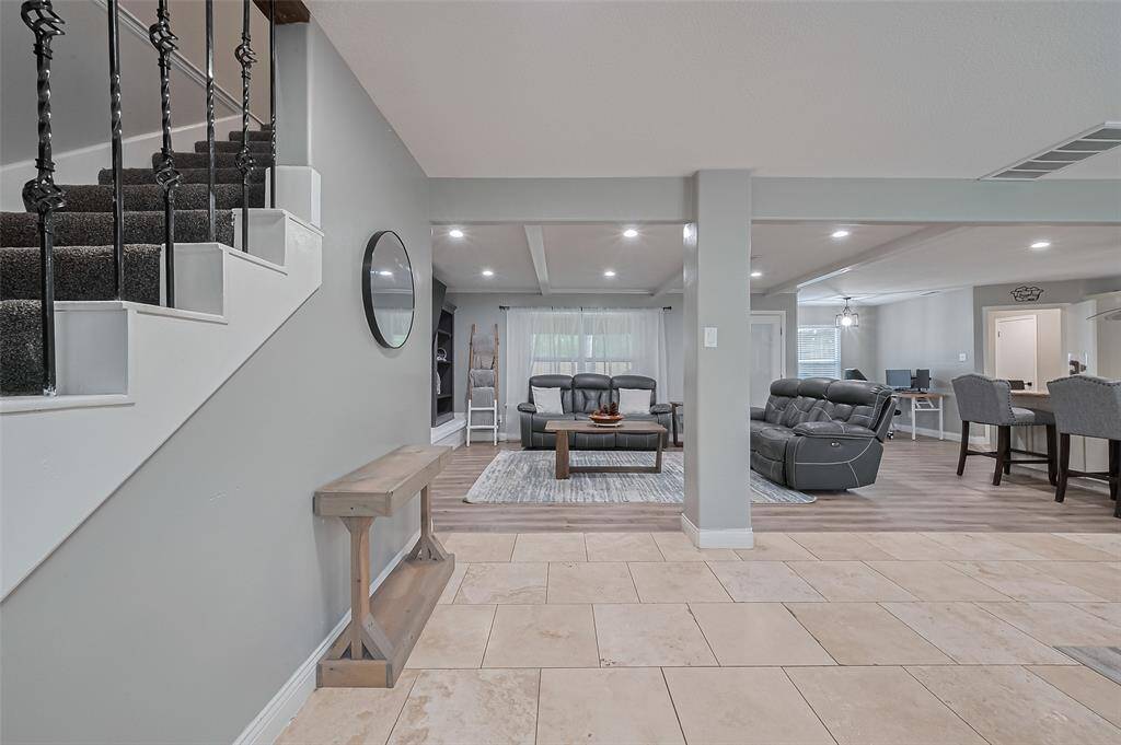 Discover the elegance of this open-concept living area, featuring modern design with neutral tones. Enjoy a cozy seating area, inviting dining space, and a stylish kitchen. The combination of smooth travertine and luxury vinyl flooring adds a perfect touch of sophistication.