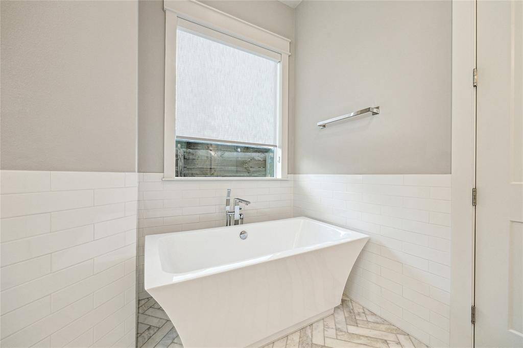The sleek and luxurious master bath features dual vanities + gorgeous herringbone patterned marble flooring  +separate shower and soaking tub.