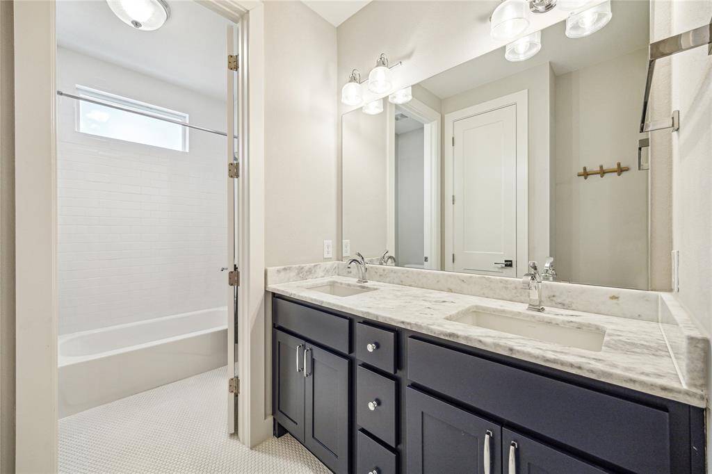 The charming secondary bathroom features double sinks + private water closet area.