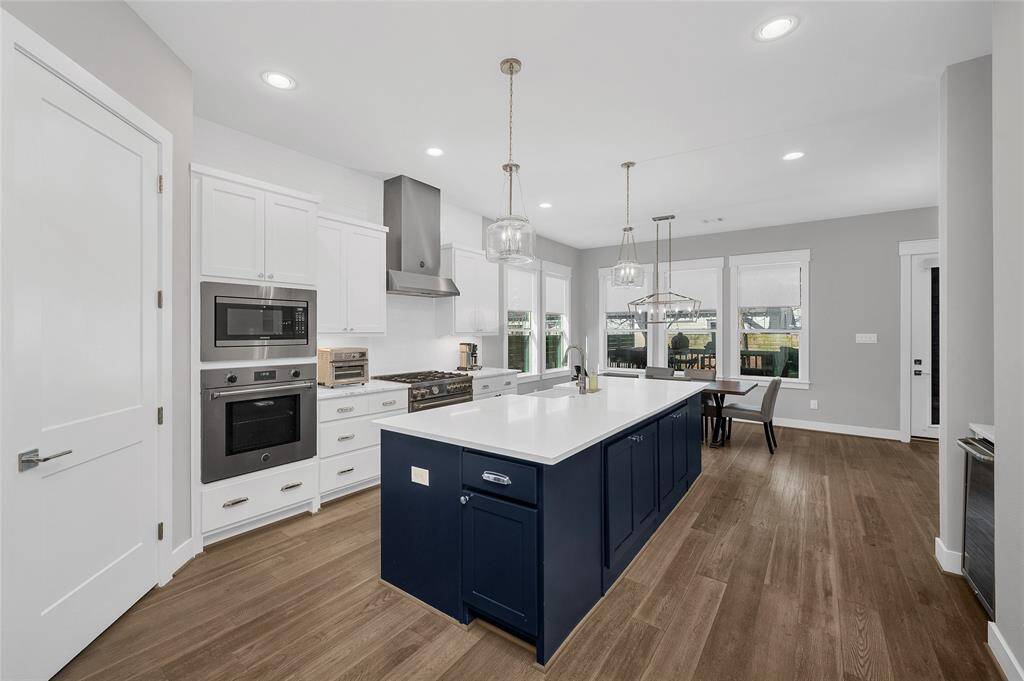The gourmet kitchen features and oversized island, quartz countertops, upgraded appliance package, walk in pantry plus dry bar area with wine fridge.