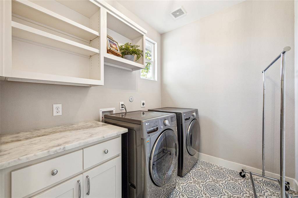The laundry room is conveniently located on the second floor and includes counter prep space + overhead storage. The tasteful decorative floor tile finishes off the space nicely.