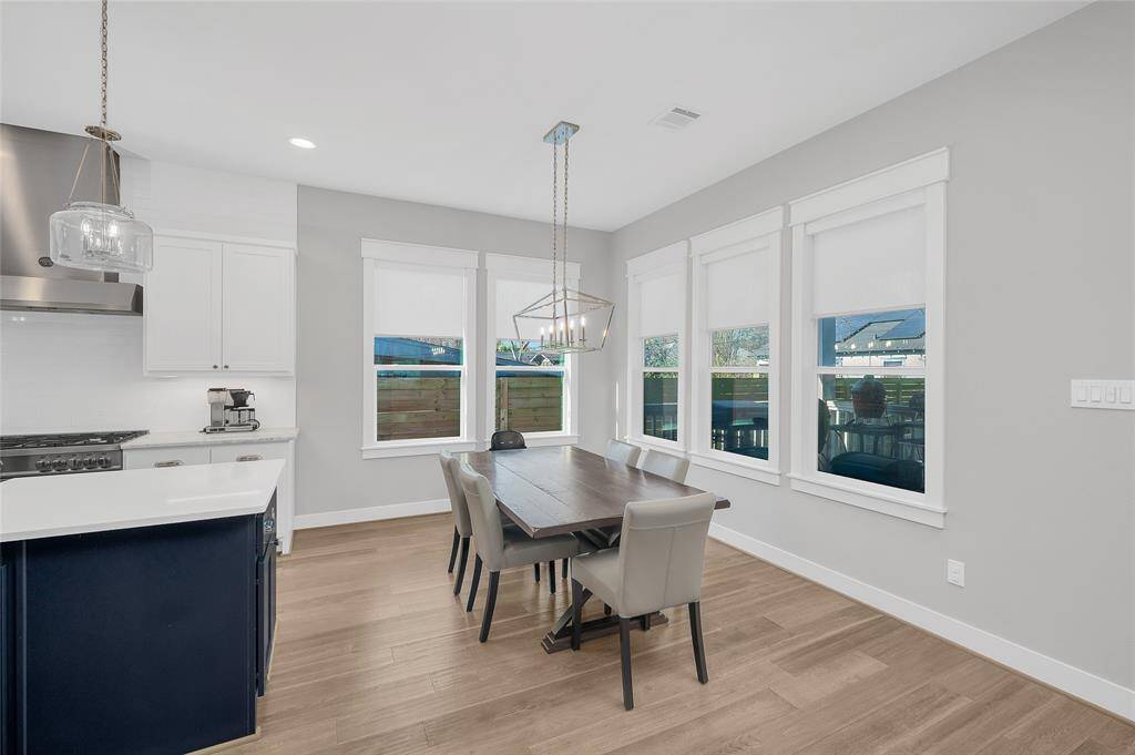 Open concept living w/designated dining space + beautiful chandelier + window which overlooks the covered patio + fantastic back green space.