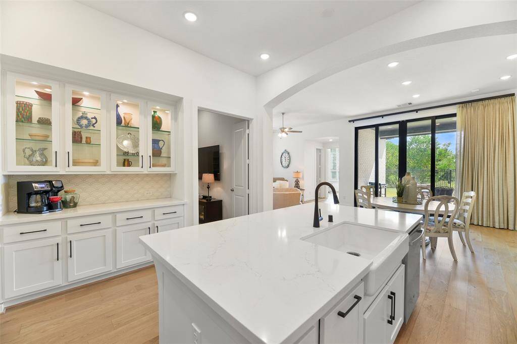 Opposite the main part of the kitchen is a built-in serving bar that's perfect for a coffee station with tons of countertop space. The upper cabinets offers glass fronts with lit interiors for showcasing your treasures.